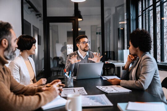 GROUP OF PEOPLE IN MEETING